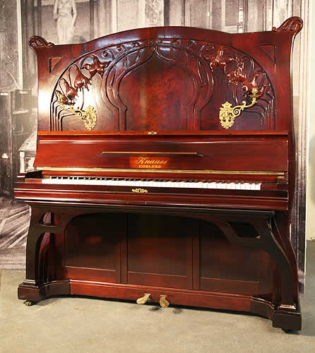 這是一架藝術外殼的 Knauss 諾恩斯立式鋼琴，外殼為桃花心木，雕刻有精美的花朵和植物莖葉。